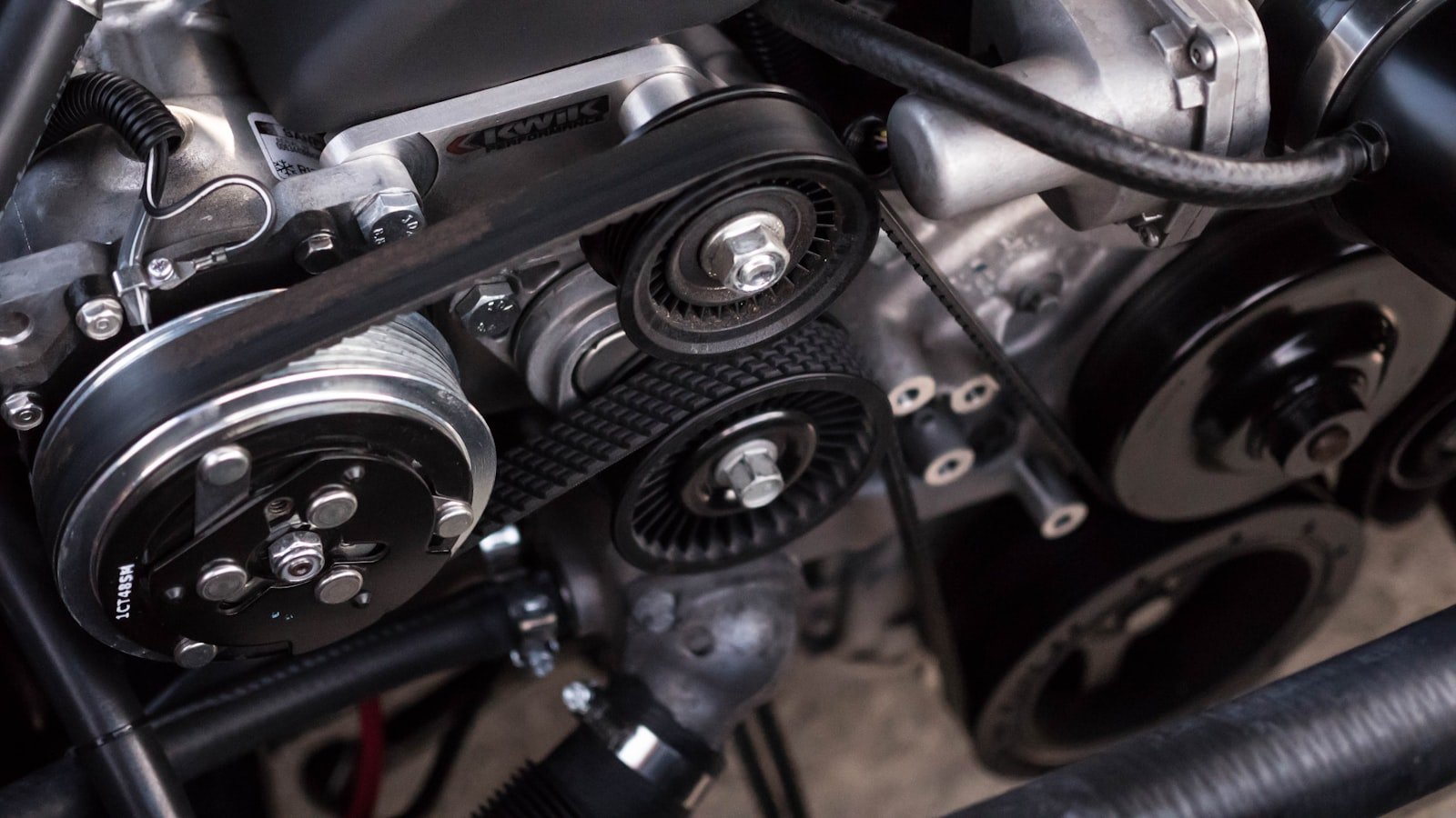 Close-up of diesel engine belts and pulleys during repair at Quality Truck Repair Inc. in Bloomington, CA